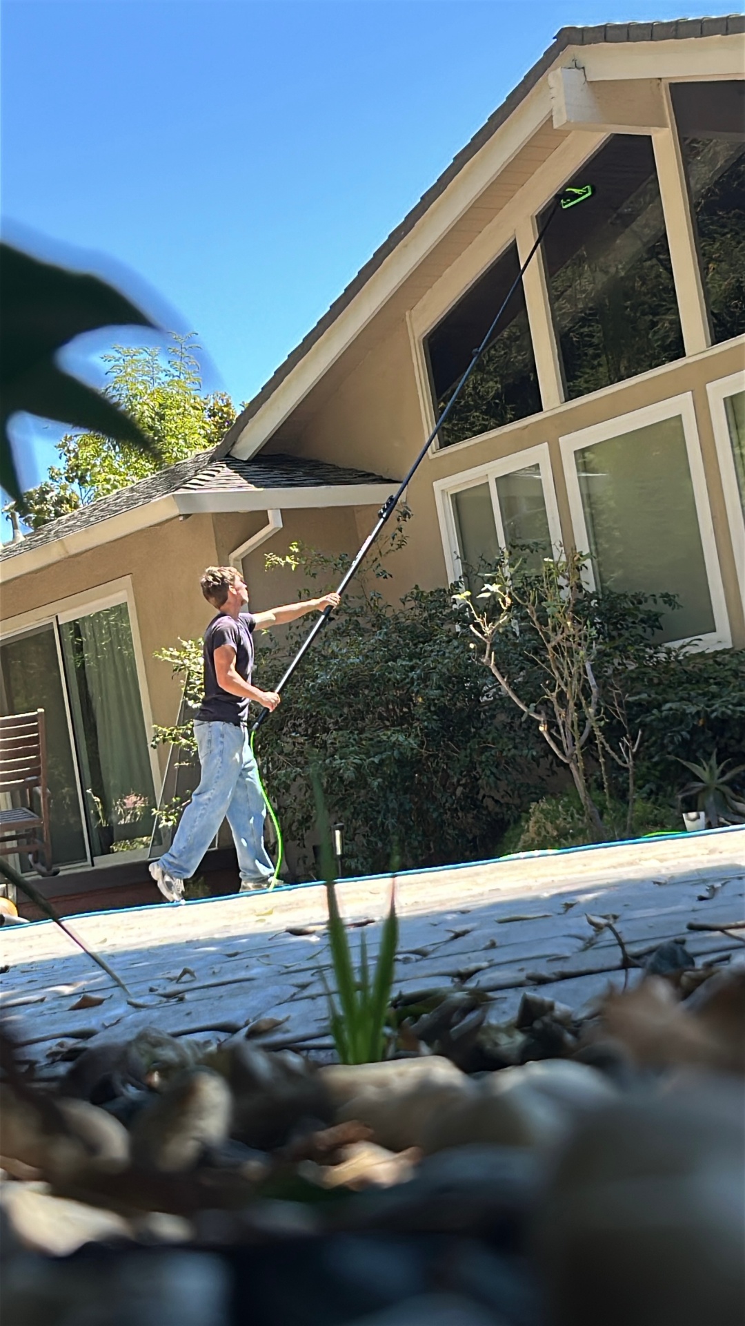 CleanLime technician washing tall windows on a Bay Area home