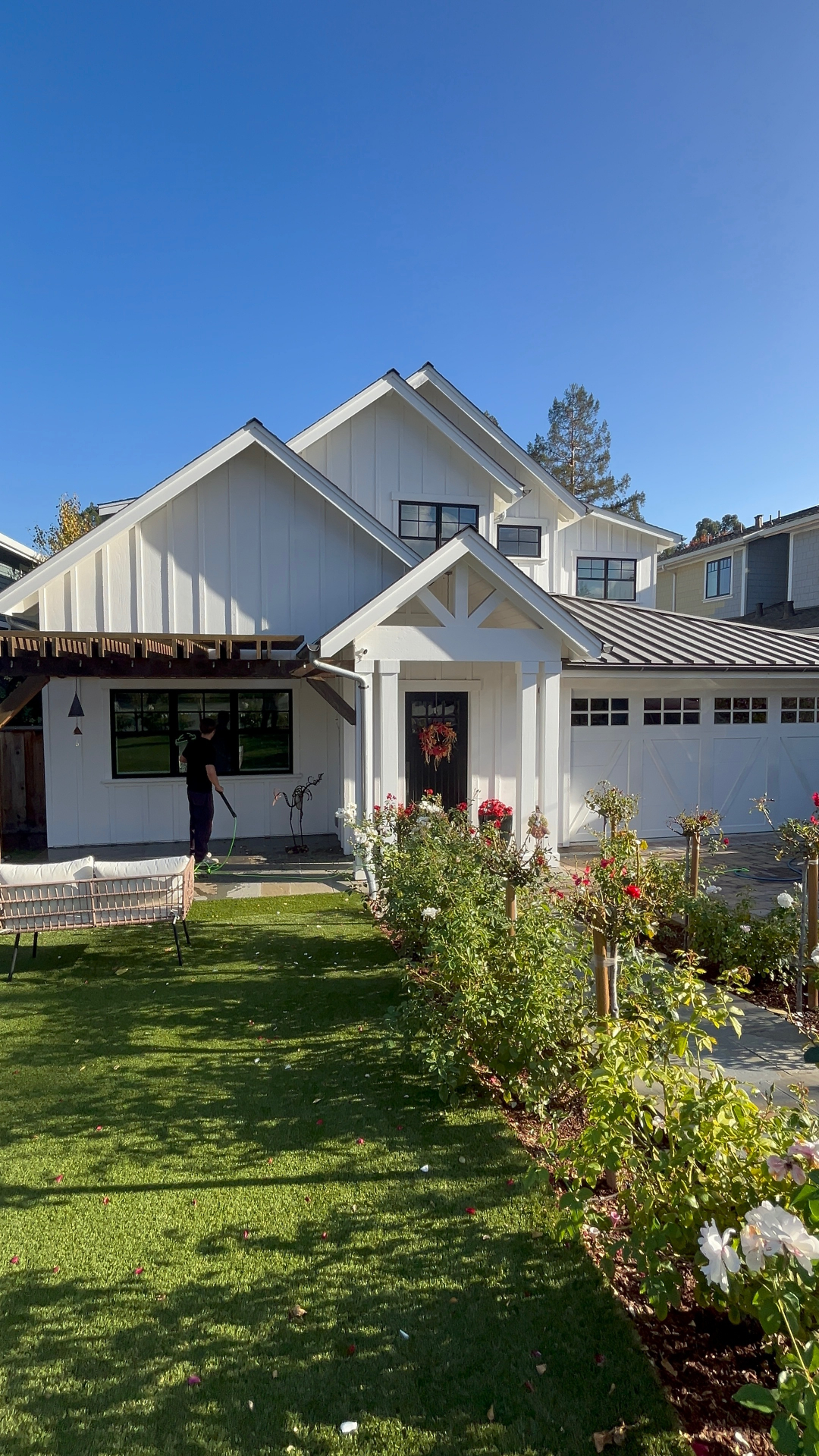 CleanLime technician washing a white modern farmhouse exterior