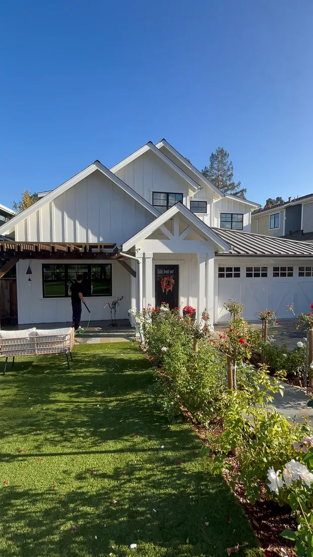 CleanLime technician washing a white modern farmhouse exterior